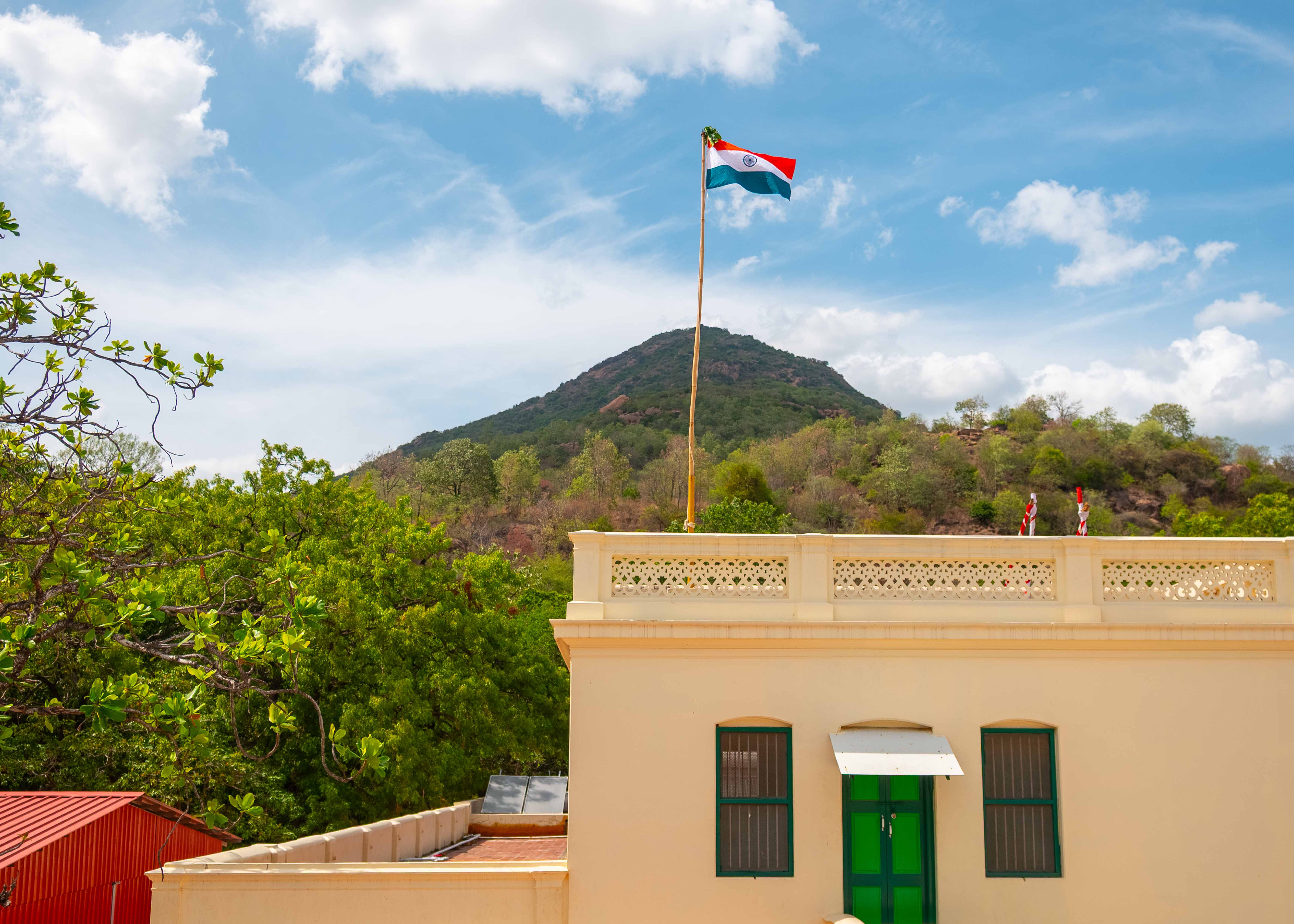Indian national flag flying over Sri Ramanasramam with Arunachala hill in the background